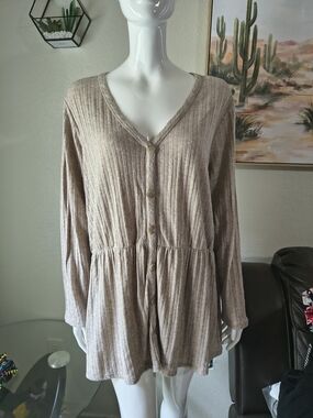 This top is an oatmeal-colored babydoll sweater from Lane Bryant.